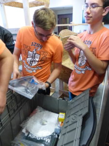 Team members opening the kit of parts and inspecting its contents